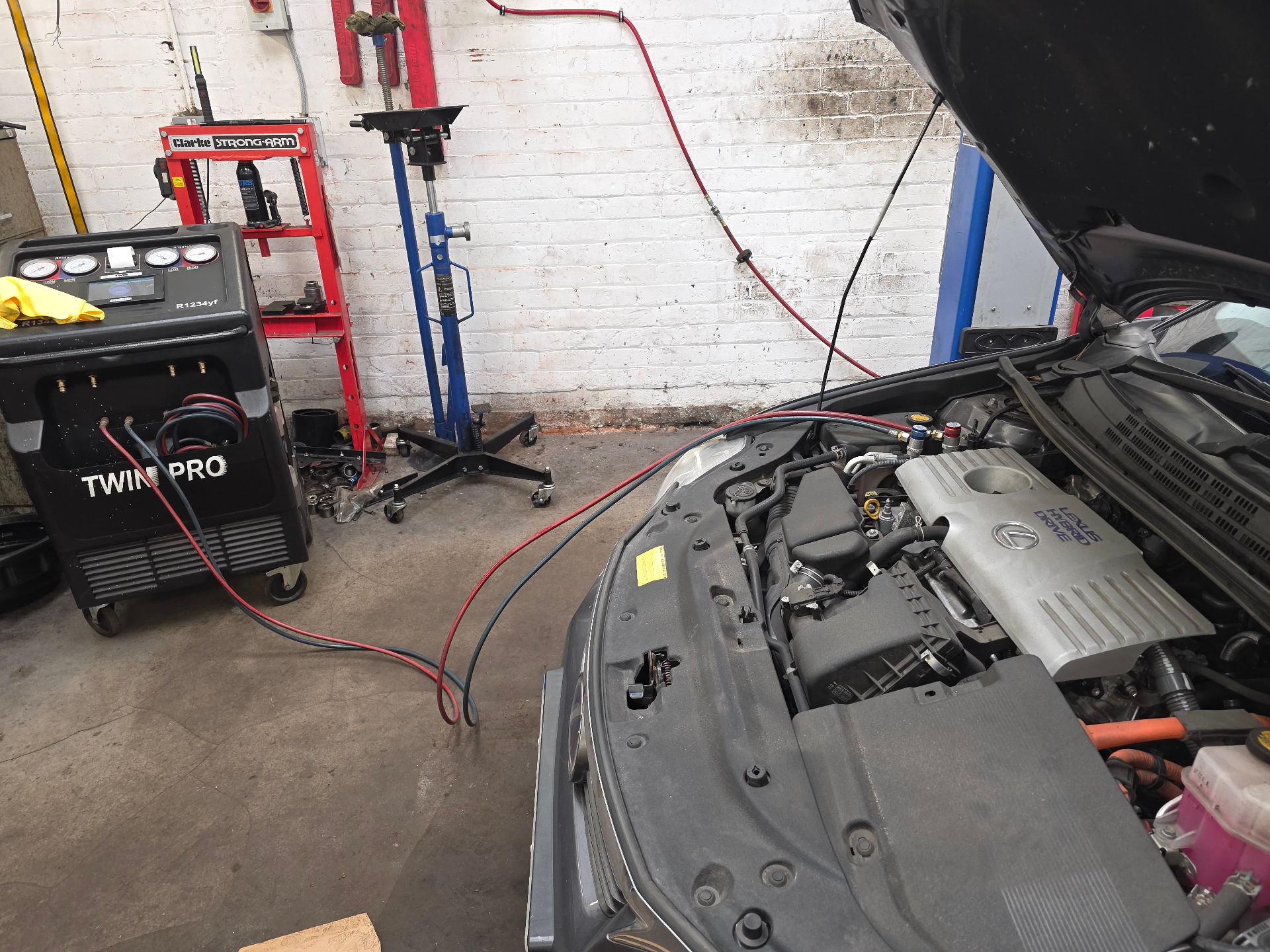 Air conditioning regas machine connected to a vehicle engine bay at Hadfield Service Centre